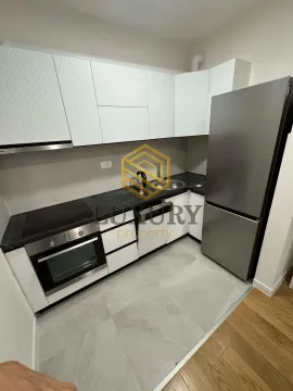 Small kitchen with white cabinets, built-in oven, and refrigerator. - image 9