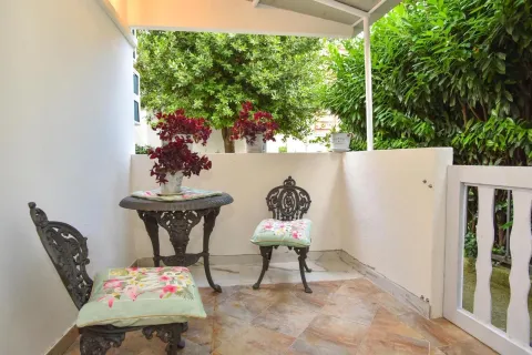 Covered terrace with a table, chairs, and decorative plants. - image 2
