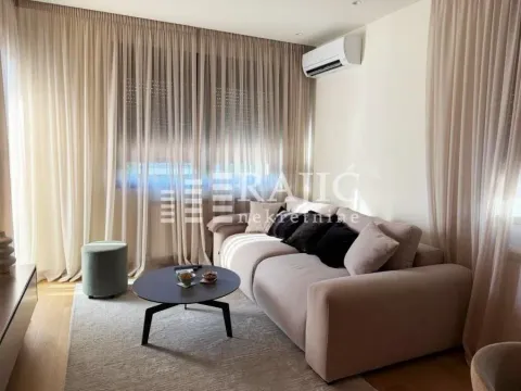 Living room with a comfortable sofa and large windows with drapes. - image 3