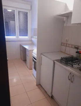 Manja kuhinja sa bijelim elementima i prozorom. - image 3