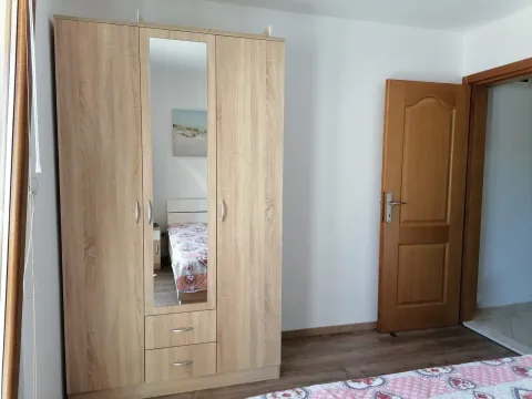 Spavaća soba sa drvenim ormarom i krevetom. - image 7