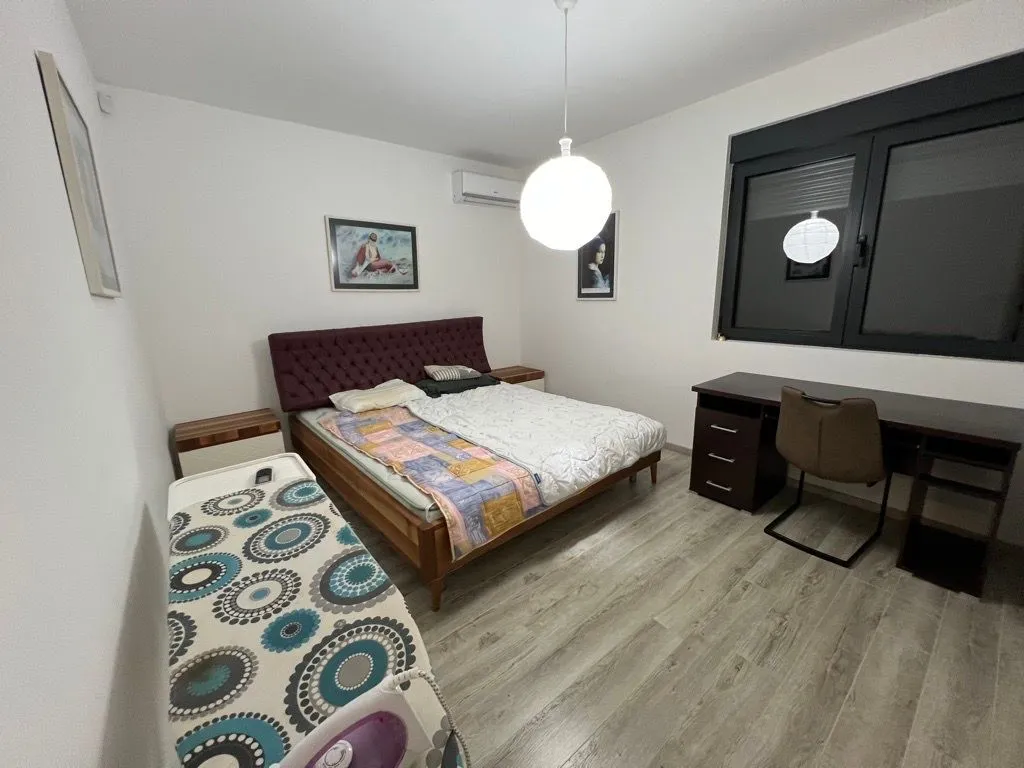 Bedroom with a double bed, desk, and laminate flooring.