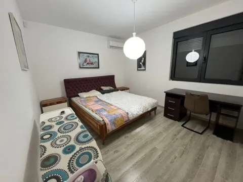 Bedroom with a double bed, desk, and laminate flooring. - image 6