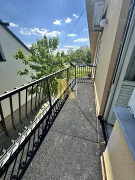 Dugačak spoljni balkon sa metalnom ogradom i pogledom na zelenilo. - image 12