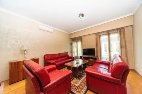 Living room with red leather sofas, a coffee table, and a TV. - image 2