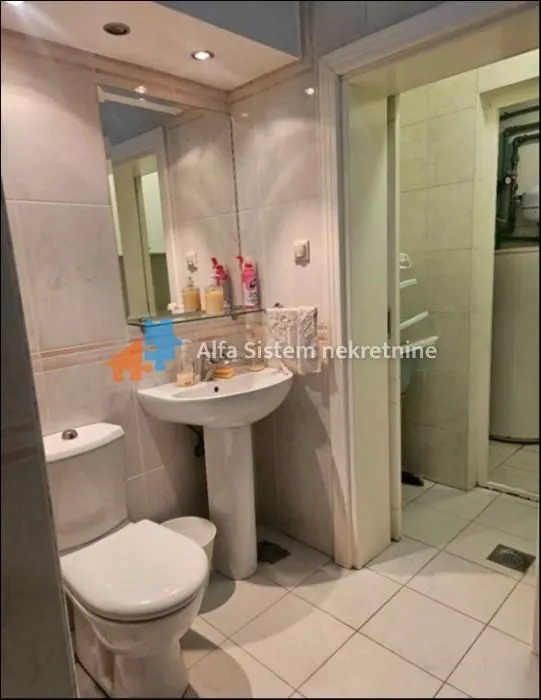 Bathroom equipped with a washbasin, toilet, and mirror.