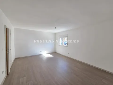 Prazna svetla prostorija sa belim zidovima i laminatom. - image 5