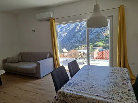Living room with a dining area and access to a terrace with mountain views. - image 7