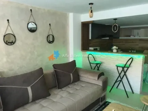 Living room with a sofa and a view of the kitchen bar. - image 7