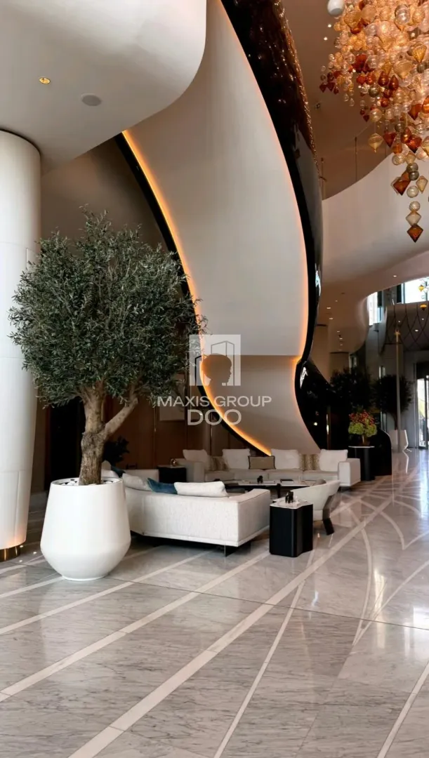 Spacious luxury living room with modern furniture and a large staircase.