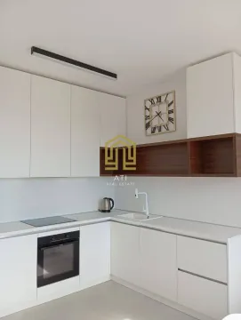 Moderna bijela kuhinja sa ugradnim aparatima i zidnim satom. - image 6