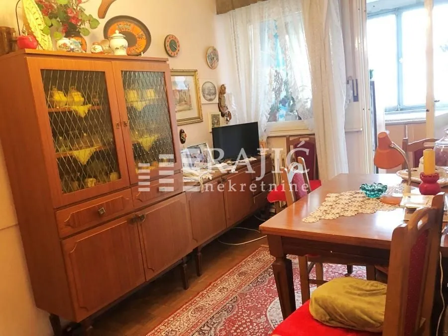 Living room with dining area and wooden furniture.