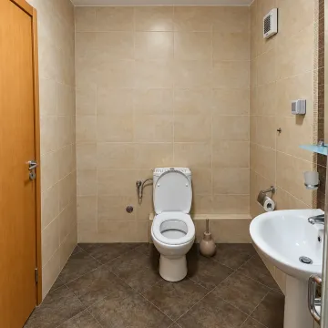 Kupatilo opremljeno WC šoljom, umivaonikom i pločicama u bež tonovima. - image 12