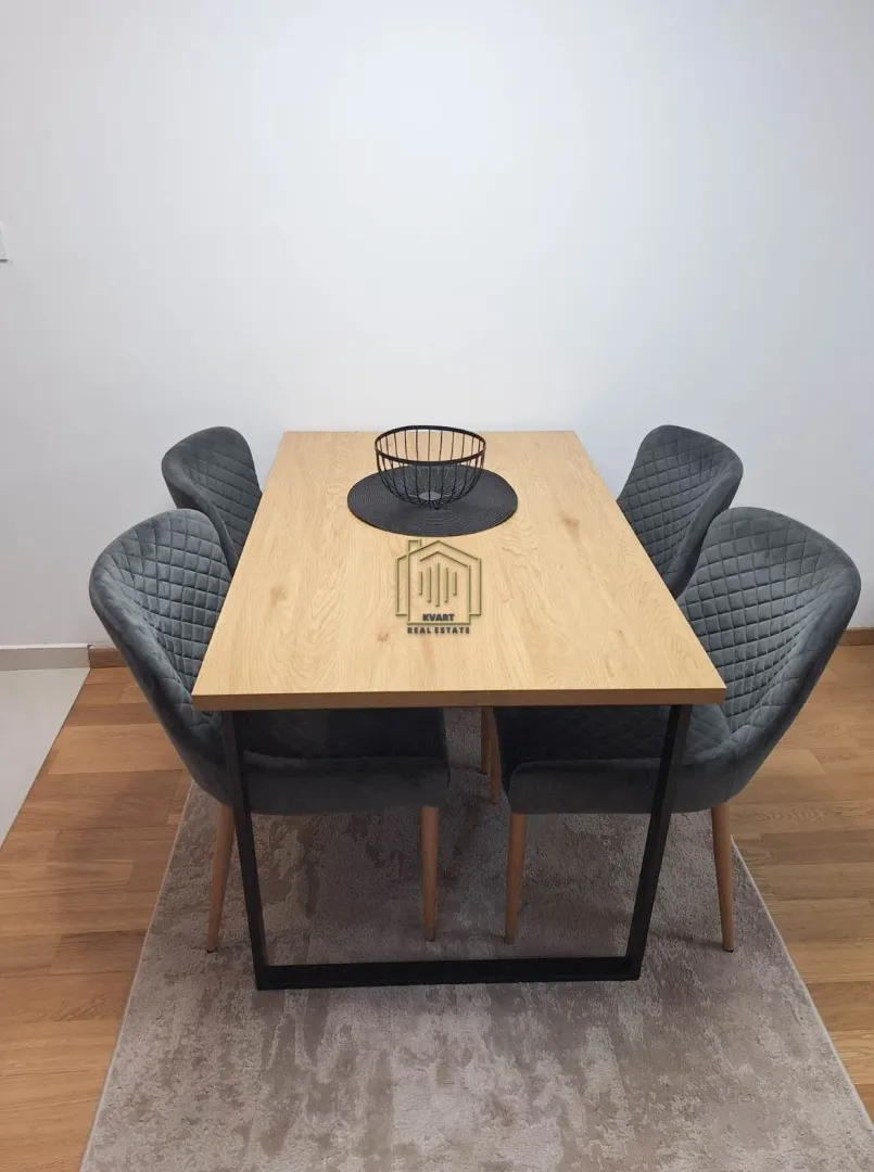 Dining table with four upholstered chairs and a decorative basket.