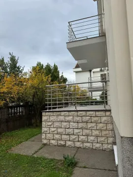 Exterior view of a modern building featuring a paved terrace with metal railings. - image 2