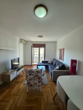 Dnevna soba sa garniturom, TV komodom i izlazom na terasu. - image 3