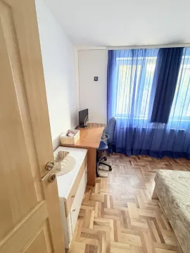 Manja spavaća soba sa krevetom, radnim stolom i plavim zavesama. - image 10