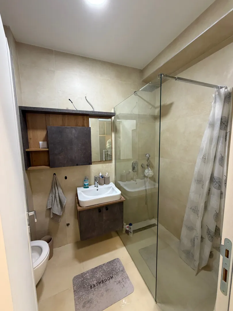 A modern bathroom equipped with a walk-in shower and a vanity unit.