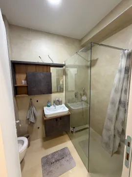 A modern bathroom equipped with a walk-in shower and a vanity unit. - image 11