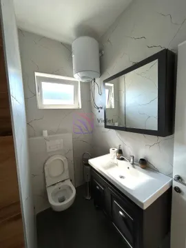 Savremeno opremljeno kupatilo sa umivaonikom, WC šoljom i zidnim ormarićem sa ogledalom. - image 15