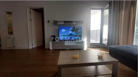 Dnevna soba sa televizorom, drvenim stočićem i izlazom na terasu. - image 3