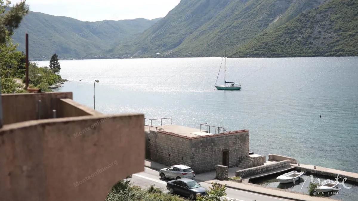 Pogled na zaliv, planine i jedrilicu sa terase.