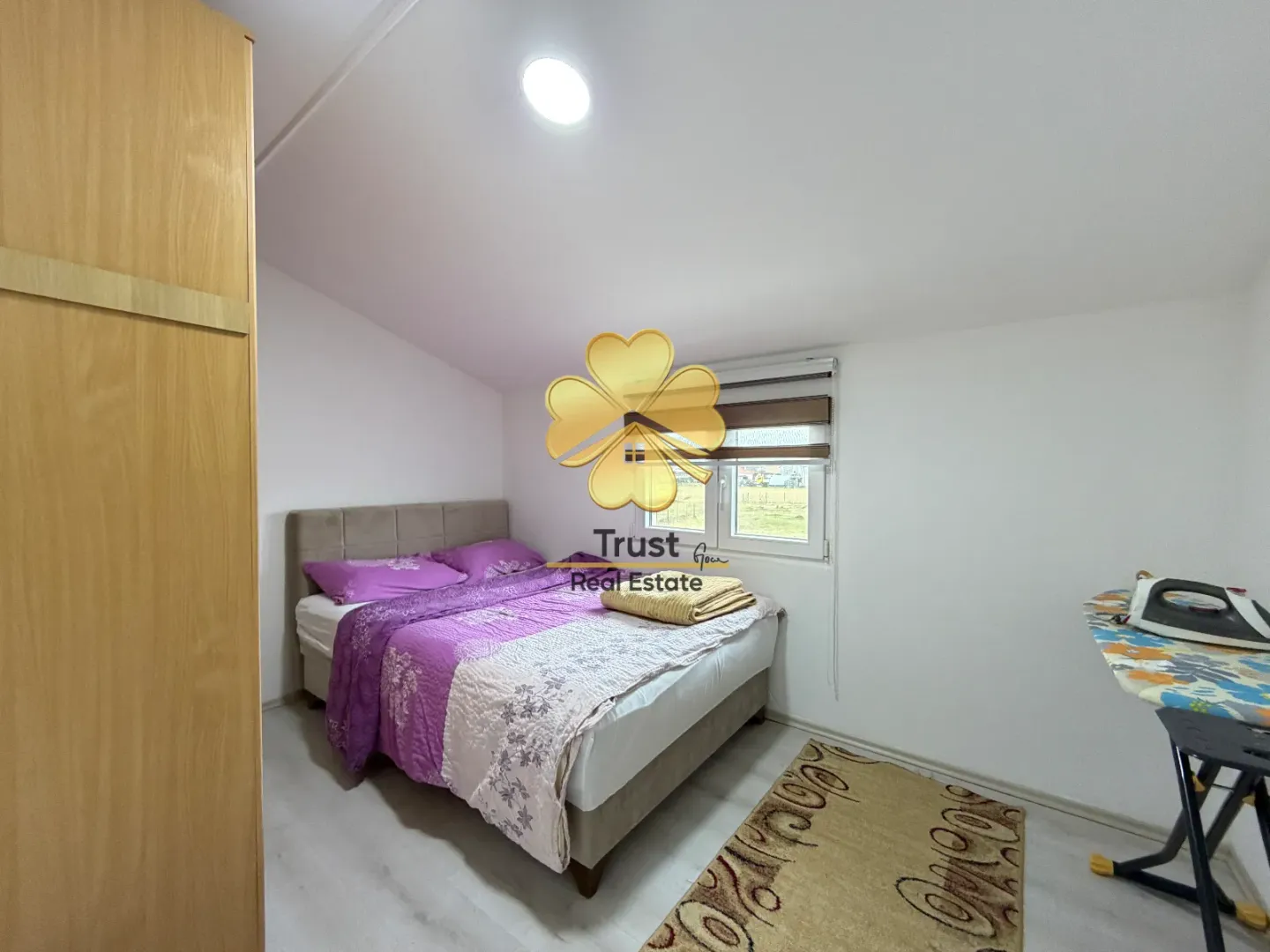 Furnished bedroom with a double bed and a wardrobe.