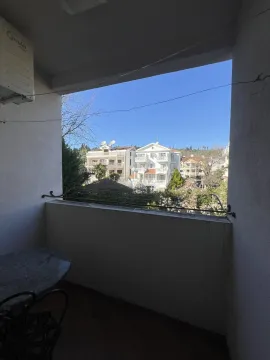 View from the terrace overlooking nearby buildings under a clear sky. - image 25
