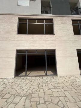 Exterior of a commercial space with large glass portals and a paved courtyard. - image 4