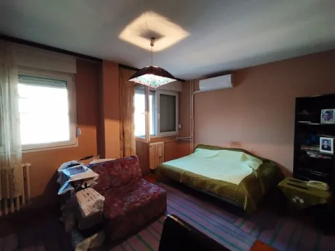 Spavaća soba sa krevetom, foteljom i prozorima koji propuštaju dnevnu svetlost. - image 7