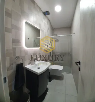 Modern bathroom with sink, shower cabin, and toilet. - image 3