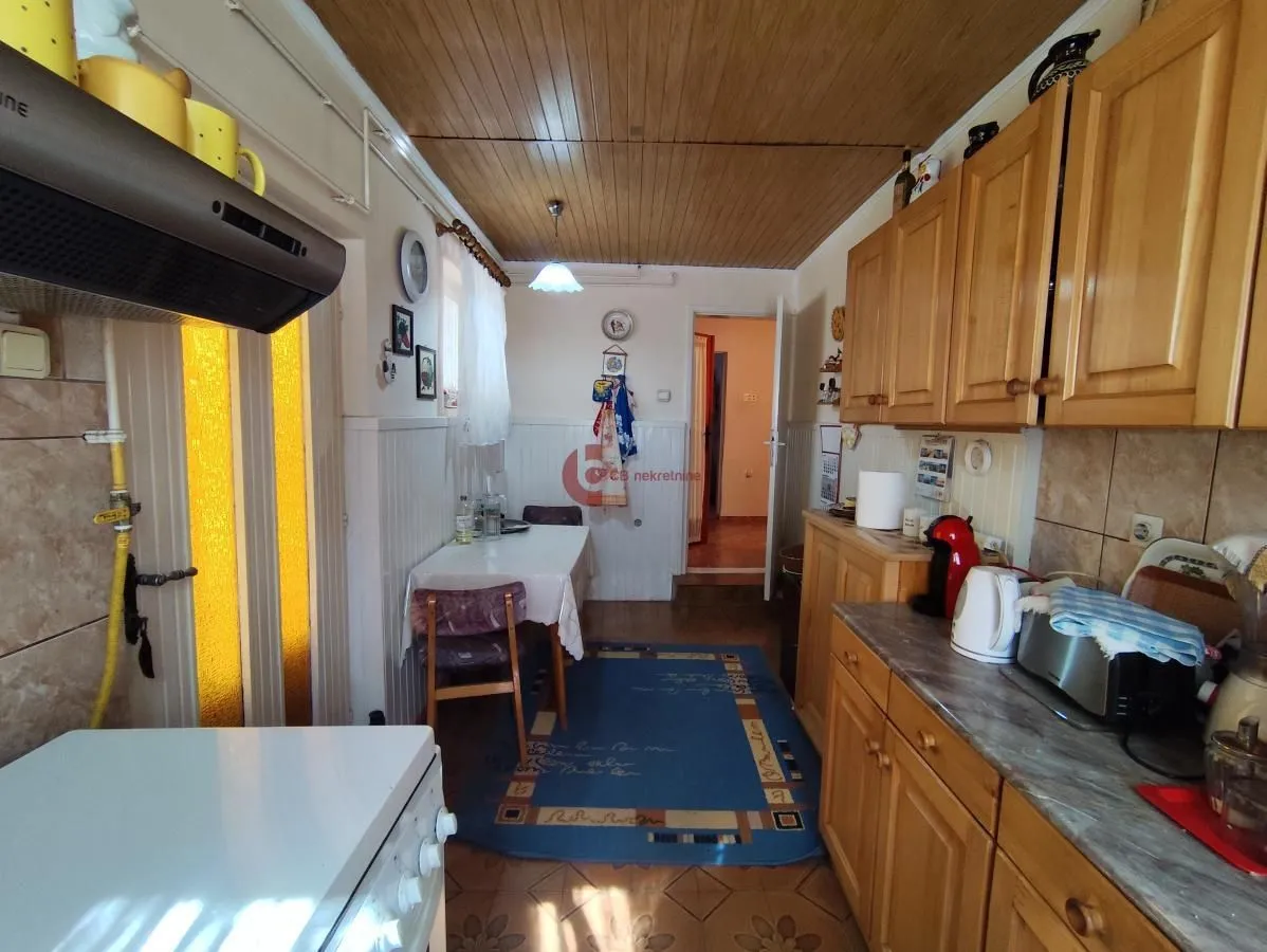 Small kitchen with wooden cabinetry and a dining table.