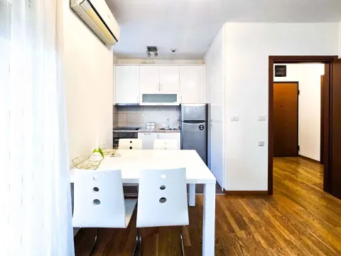 A bright kitchen and dining table with white chairs. - image 3