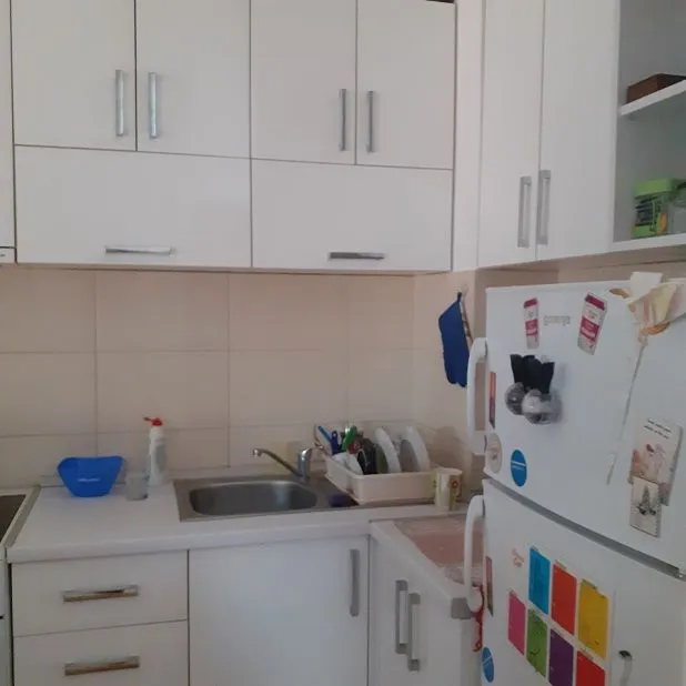View of part of a white kitchen with cabinets and a sink.
