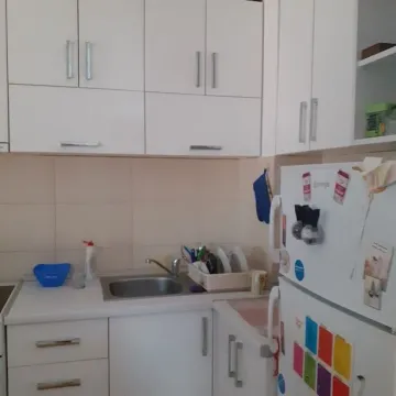 View of part of a white kitchen with cabinets and a sink. - image 5