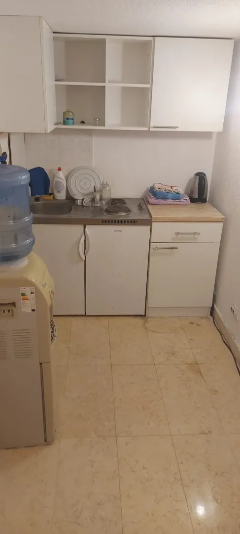 Small kitchen with white cabinets and a sink.