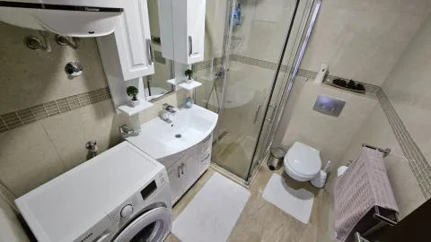 Kompaktno kupatilo opremljeno umivaonikom, tuš kabinom, toaletom i veš mašinom. - image 25