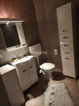 Kupatilo opremljeno umivaonikom, WC šoljom i belim nameštajem. - image 14
