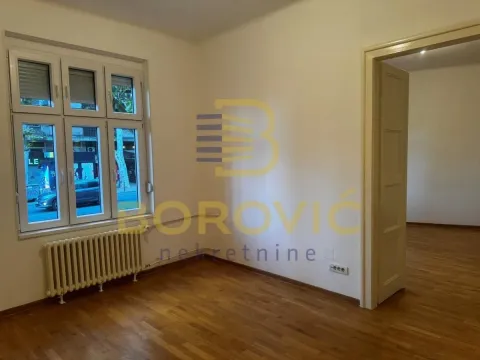 Prazna soba sa parketom i prozorom koji gleda na ulicu. - image 6