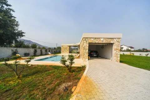 View of the courtyard with a swimming pool, garage, and landscaped green area. - image 11