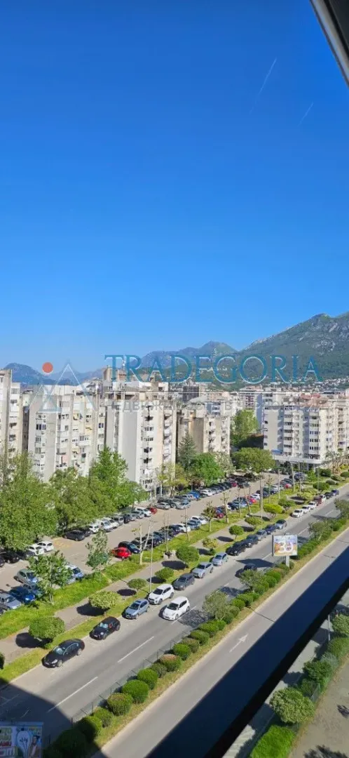 Pogled sa prozora na gradsko naselje i okolne planine.