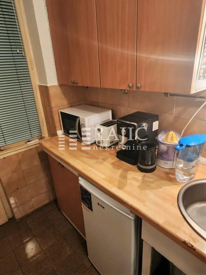 View of part of the kitchen with wooden cabinets and countertop.