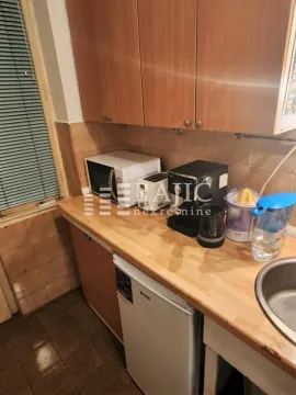 View of part of the kitchen with wooden cabinets and countertop. - image 8