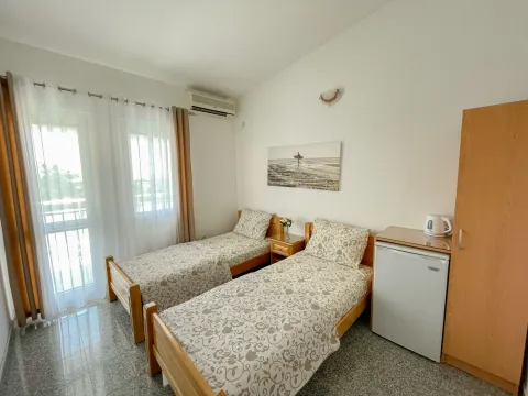 Bedroom with two single beds, a wardrobe, and balcony doors. - image 6