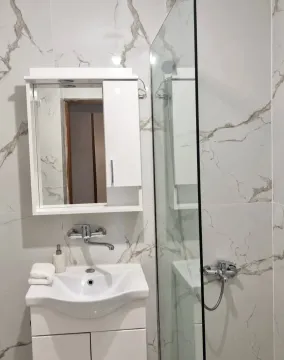 Savremeno opremljeno kupatilo sa umivaonikom, ogledalom i tuš kabinom. - image 6