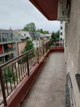 Dugačka popločana terasa sa metalnom ogradom i pogledom na okolne zgrade. - image 41