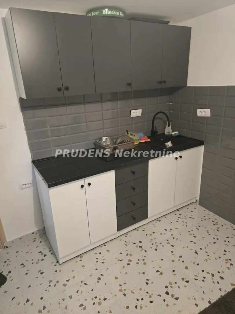 Smaller kitchen with lower and upper cabinets and a sink.
