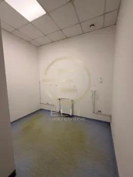 Empty office space with a dropped ceiling and radiator. - image 13