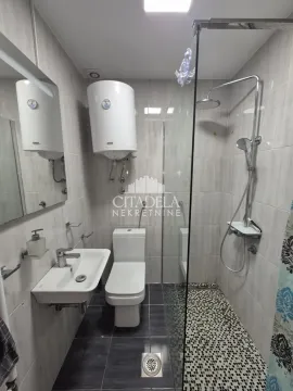 Kupatilo opremljeno umivaonikom, WC šoljom i tuš kabinom. - image 15