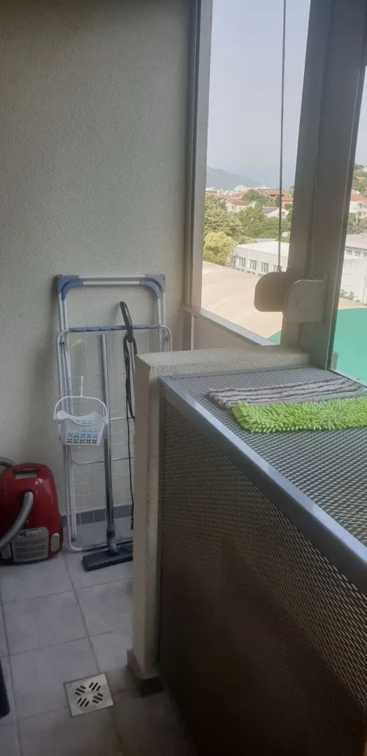 Zastakljeni balkon sa pogledom na naselje.